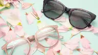 Two pairs of glasses on a green background