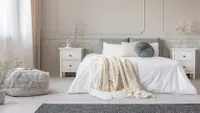 a mostly white bedroom with various fabric blankets