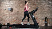 A woman uses a treadmill for a home gym.