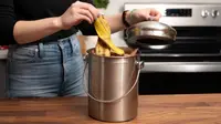 Woman putting banana peel into stainless steel countertop compost bin.