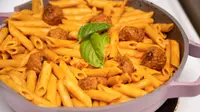 A pot of manicotti pasta cooked in tomato sauce with meatballs in an Always pan.