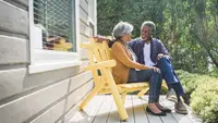 A couple sits on an outside porch.