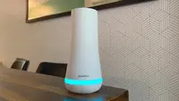 SimpliSafe base station sits son a wood dining room table.