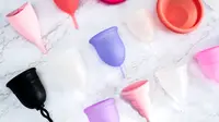 colorful menstrual cups on white marble background