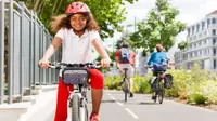 Girl with on a bike wearing a red helmet