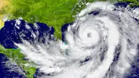 A satellite image of a hurricane swirling between Florida and Cuba