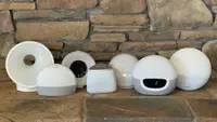 Seven sunrise alarm clocks lined up next to each other on a neutral stone background