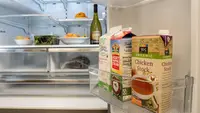 A shot of the interior of a fridge, focusing on its door bins and the lower half of its refrigerator compartment. The fridge is stocked with food.