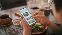 A person using a food app while eating.