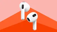 Close up of the newest Apple AirPods against a red background.