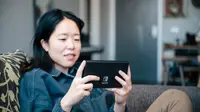 A person playing a nintendo switch oled on the couch