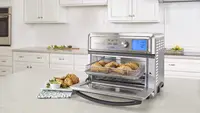 A Cuisinart Toaster Oven is being used on a kitchen table.