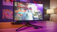 A gaming monitor sitting on top of a wooden desk