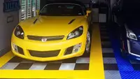 A car owner's garage flooring being used to store his cars and work on them comfortably.