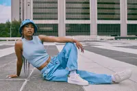 person posing in light wash wide leg jeans with white sneakers