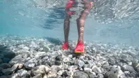 person wearing water shoes shown underwater