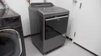 A gray Whirlpool dryer placed in a laundry room.