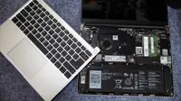 The keyboard lid lies atop the bare laptop parts.
