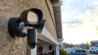 The Ring Floodlight hanging on the side of a home above a garage during the daylight