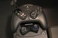 The Thrustmaster eSwap S Pro controller sitting atop a Nintendo Gamecube with spare thumbsticks on display..