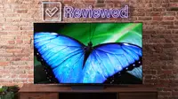 An LG G2 OLED TV with a blue butterfly displayed on its screen.