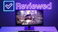 The HP X27q monitor displaying a racing video game with the Reviewed.com logo in neon light behind it.