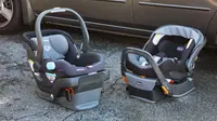 Two car seats sitting on the ground next to a car.