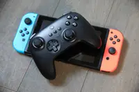 A black ultimate controller atop a nintendo switch