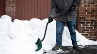 A person shoveling snow with an ergonomic snow shovel.