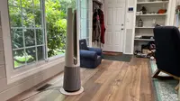 LG AeroTower Air Purifying Fan on top of hardwood floors in front of window inside of home.