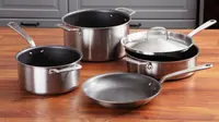 Four pieces of nonstick cookware on a wooden surface