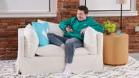 A person looking at their phone while sitting in a white lounge chair