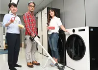 Three people standing next to the LG’s Universal Up equipment.