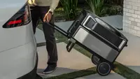 A person wheeling an EcoFlow generator into the back of a car.