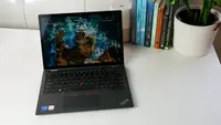 Lenovo ThinkPad L13 Yoga Gen 4 sitting on white surface next to potted plant and row of books.