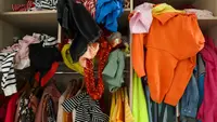 A messy closet full of unfolded clothes