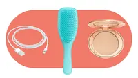 a charger cord, a blue hairbrush and a makeup compact sit on an orange oval graphic