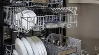 A Bosch dishwasher with its middle and upper racks open.