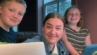 author seated at computer with kids