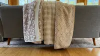 Three throw blankets placed on a couch