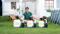 Pool owner in green shirt shown squatting behind three VEVOR sand filter pumps next to an above-ground pool, on green grass in front of a white house.