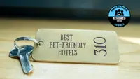 A brass hotel key with a room number on a table