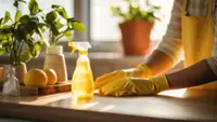 Person wearing yellow gloves cleans the kitchen counter