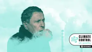 A white man coughs into his fist as smoke rises around him