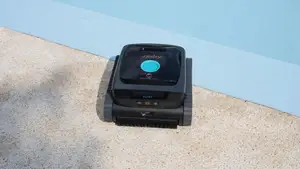 Aiper robotic pool cleaner sitting on the edge of a pool