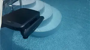 Beatbot iSkim cleaning a pool with round steps.