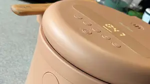 Our Place Rice Cooker in Spice with 47 minutes on timer and beechwood paddle resting on handles