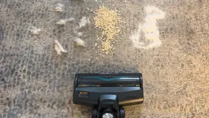 Yaber H20 cordless vacuum being used on carpet to pick up various debris.