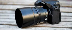 Angle on a black Lumix camera with a large zoom lens attachment on it.