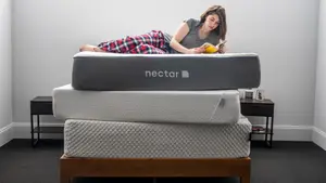 a woman lies down on a stack of mattresses reading